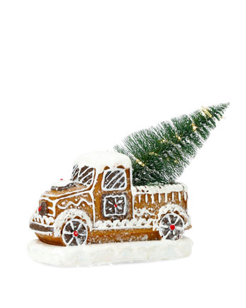 ljuslykta pepparkakslastbil i pepparkaksdesign med vit glasyrliknande dekor, röda detaljer, snötäckt bas och liten pyntad gran på flaket