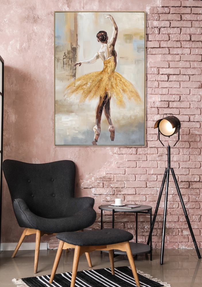 handmålad tavla ballerina i gyllene tutu hängande på rosa tegelvägg ovanför svart fåtölj