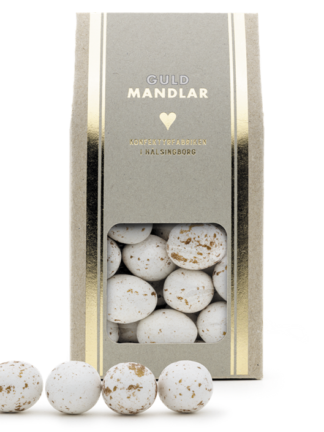beige kartong med guldrand och fönster som visar vita mandlar med guldfläckar, guldmandel 150g