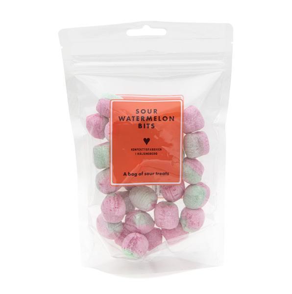 genomskinlig återförslutbar påse med rosa och gröna runda godisbitar och en röd-orange etikett, sura vattenmelonbitar.