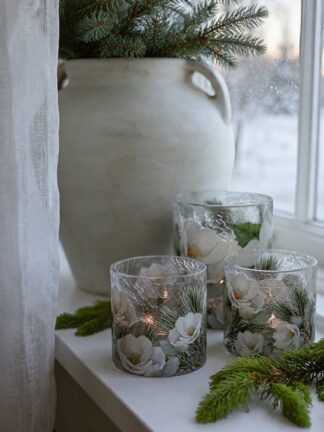 Majas lykta Winter Blossom i frostat glas med vinterblommor och tända ljus på en fönsterbräda