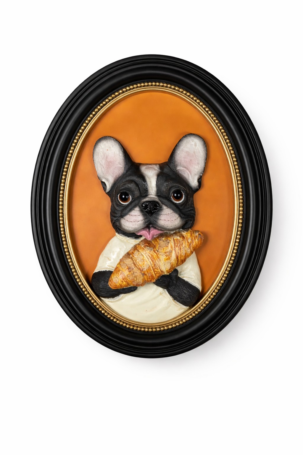 tavla söt hund i oval svart ram med en tecknad svartvit hund som håller en croissant mot en varm orange bakgrund